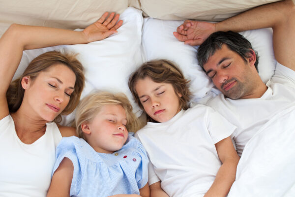 Loving family sleeping together lying in the bed